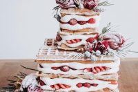 63 a waffle wedding cake with fresh strawberries and raspberries, greenery and pink and red blooms