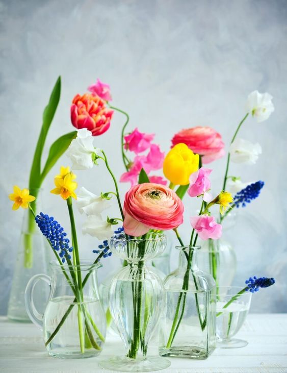 a lovely cluster wedding centerpiece in glass vases with tulips, roses,muscari, narcissus, eustoma and hyacinths