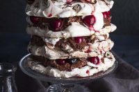 a crispy and marshmallowy pavlova wedding cake with dark chocolate mousse, whipped cream and syrupy cherries