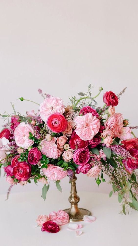 a gorgeous wedding centerpiece of pink peonies, fuchsia peony roses, pink ranunculus and greenery and astilbe is fantastic for a Valentine's Day wedding