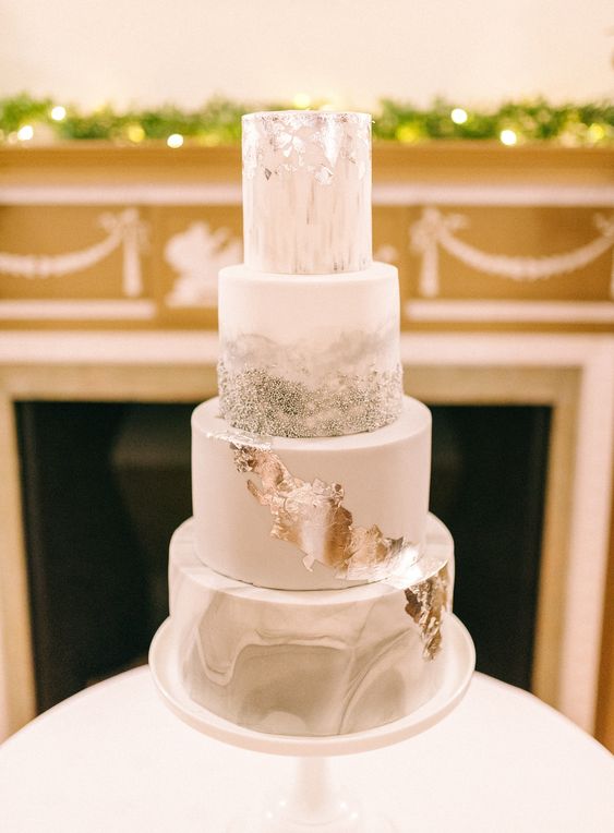 a lovely wedding cake with a grey marble, white, silver glitter and silver leaf tier is a gorgeous and shiny idea for a winter wedding