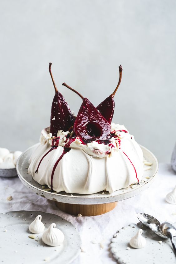 a marshmallowy pavlova wedding cake topped with berries poached in hibiscus and spices is a decadent wedding dessert idea for a fall wedding