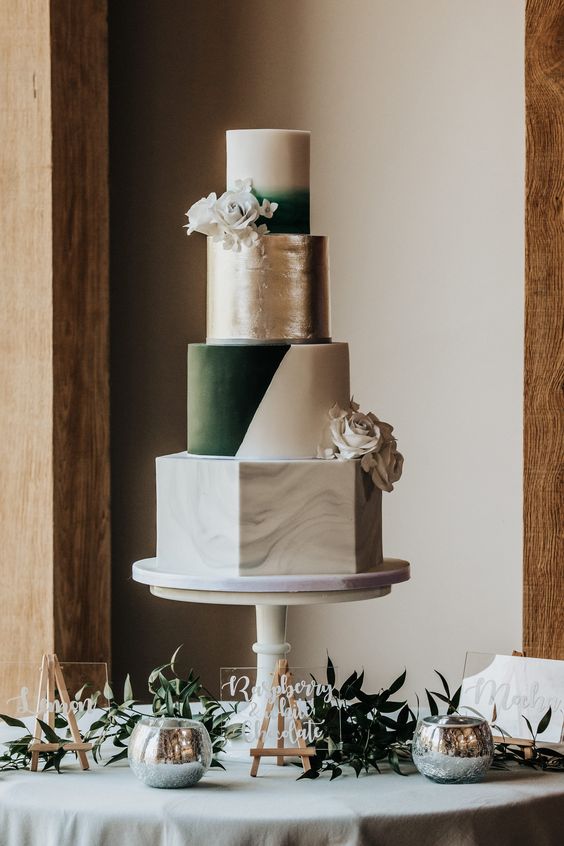 a multi-tier wedding cake with a marble, color block, silver leaf and ombre tiers, with white blooms is dramatic and extra bold