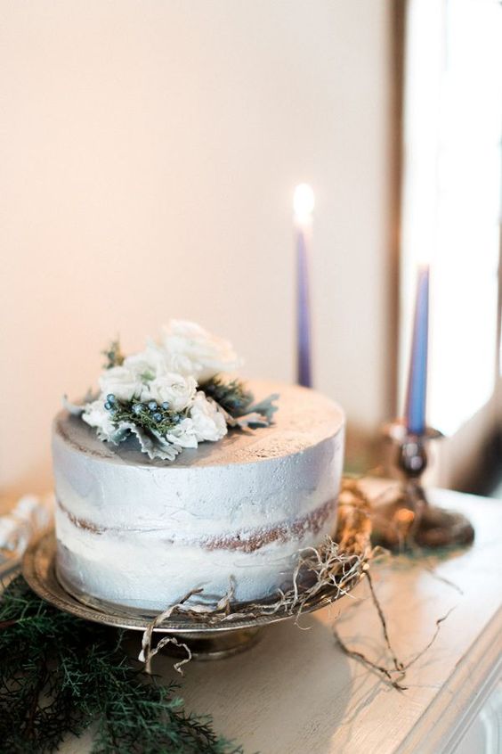 a naked one-tier wedding cake with a silver touch, with white blooms and pale leaves on top is a beautiful and refined idea for a neutral winter wedding