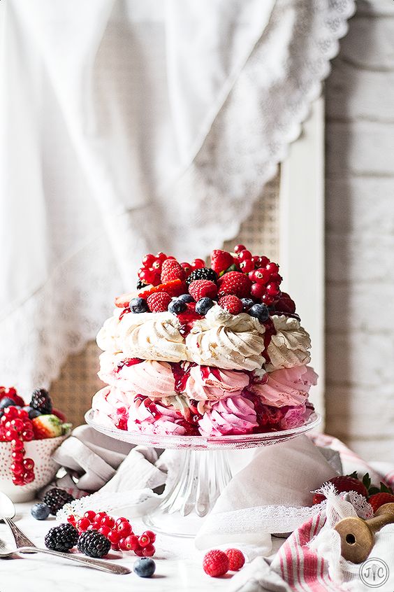 a pavlova wedding cake of three tiers   a hot pink, light pink and white one, with lots of delicious berries and berry drip for a summer wedding