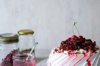 a pavlova wedding cake topped with cherries, cherry drip, pistachios is a delicious idea for a summer or summer to fall wedding