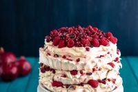 a pavlova wedding cake topped with fresh raspberries and pomegranate seeds is a gorgeous idea for a summer or fall wedding