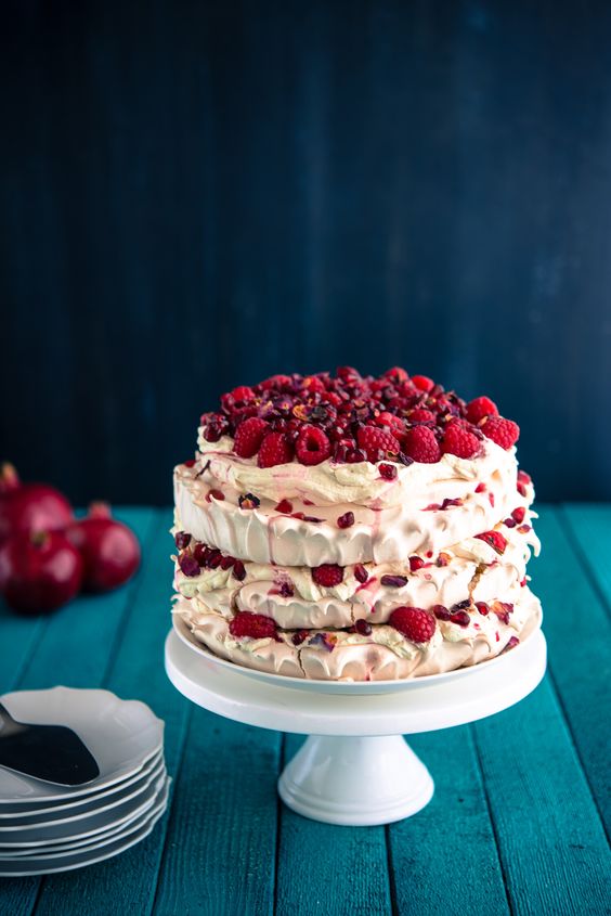a pavlova wedding cake topped with fresh raspberries and pomegranate seeds is a gorgeous idea for a summer or fall wedding
