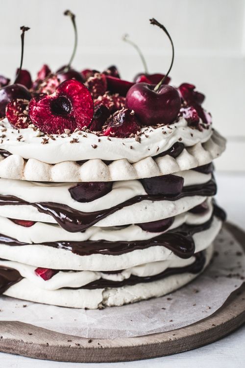 a pavlova wedding cake with chocolate drip, fresh cherries and chocolate on top is a lovely idea for a summer or fall wedding