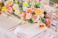 a pretty summer wedding bouquet with yellow and blush ranunculus, pink and blush roses, some blush fillers and a bit of greenery