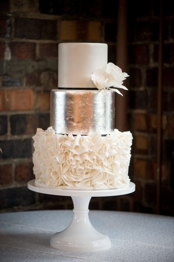 a refined wedding cake with white, silver leaf, white flower wedding cake with white blooms and black ribbon is a very chic idea