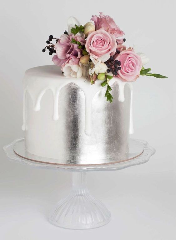a silver leaf wedding cake with creamy drip and some fresh pink blooms and berries on top is a beautiful and refined idea to rock