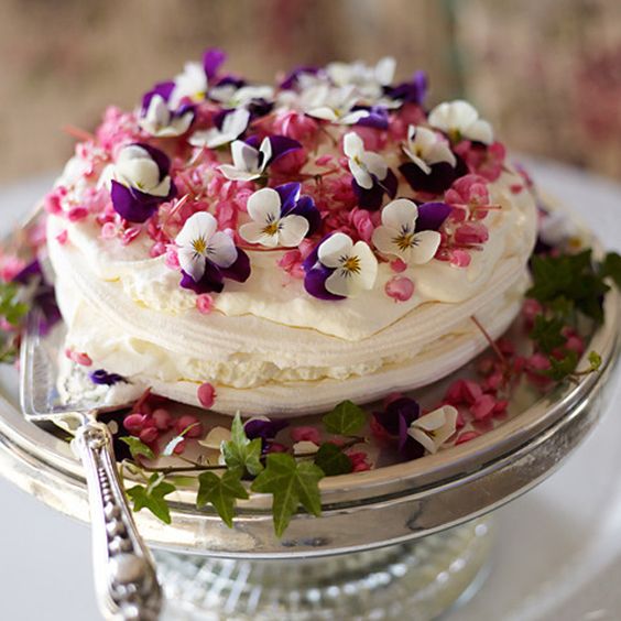 a simple pavlova wedding cake topped with berries and pansies is a lovely idea for a summer wedding, looks bold and cool