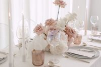 a sophisticated neutral wedding tablescape with neutral linens, grey plates, neutral and blush candles, a beautiful blush and white rose centerpiece