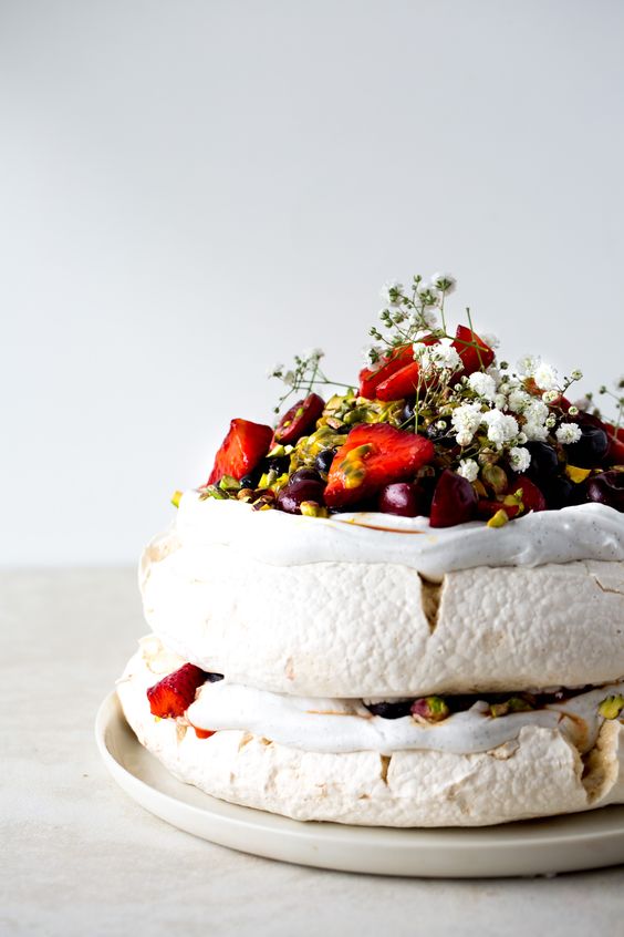 a vegan, dairy-free, egg-free pavlova wedding cake with fresh berries and baby's breath and nuts is a fantastic idea for a summer wedding