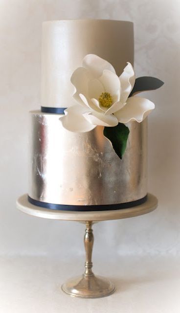 an elegant wedding cake with a tan and a silver leaf tier, with a large white sugar bloom with leaves is stunning idea