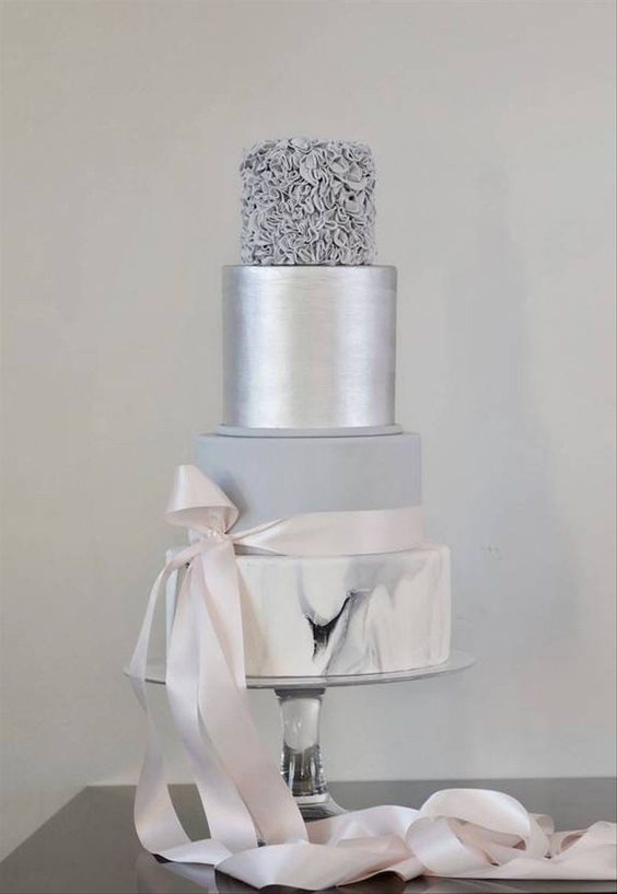 an exquisite wedding cake with a silver leaf, a matte grey, a grey floral and marble tier, with a ribbon with a bow is a beautiful solution for a winter wedding