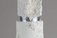 a fabulous winter wedding cake with white and silver glitter tiers, snowflakes and some white sugar blooms is wow