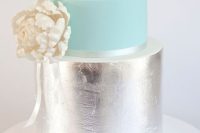 a glam wedding cake with a mint and silver tier plus a white sugar bloom on the side is cool