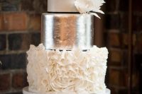 a glam wedding cake with a white, silver and white ruffle tier plus some sugar blooms on one side