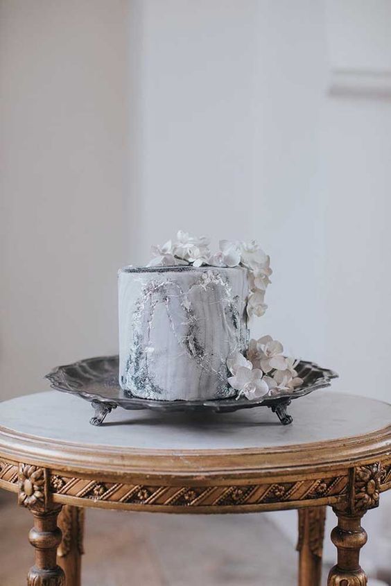 a marble wedding cake with silver leaf and whiet orchids is a very sophisticated and ultra-modern idea