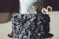 a moody glam wedding cake with marble layers and a black ruffle layer plus silver leaf touches