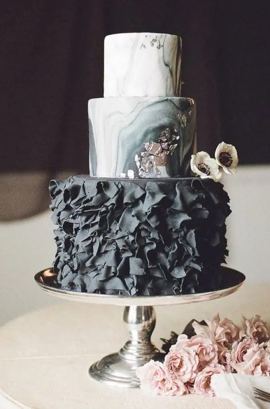 a moody glam wedding cake with marble layers and a black ruffle layer plus silver leaf touches
