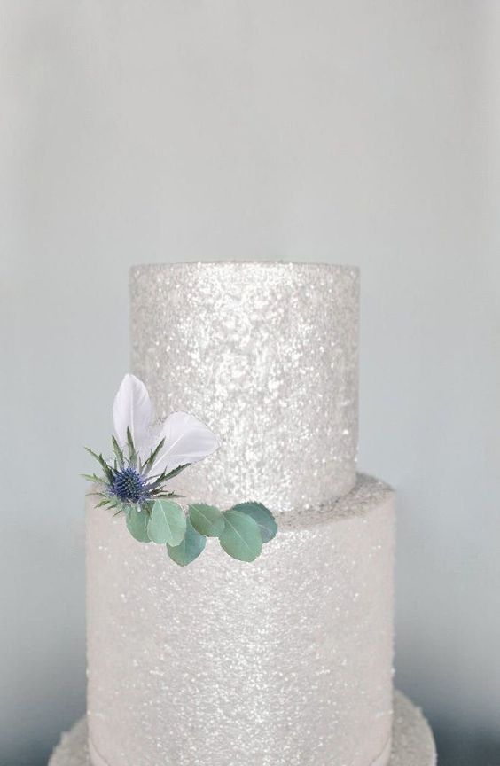 a silver glitter wedding cake decorated wiht greenery and a thistle is amazing for a modern glam celebration