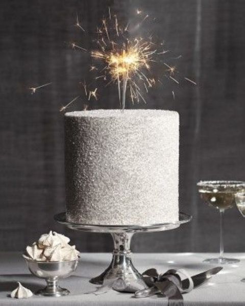 A silver glitter wedding cake with sparklers is a super cool and fun idea for a NYE wedding or pre wedding party