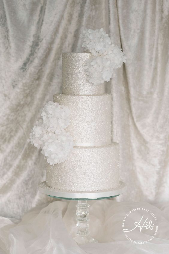 a silver glitter wedding cake with white blooms looks absolutely ethereal and very chic