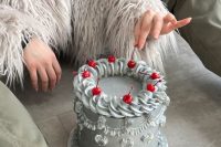 a silver lambeth wedding cake topped with cherries is a unique take on the trend that used o be everywhere