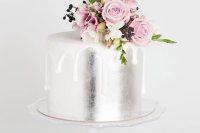 a silver wedding cake with white drip and pink blooms and berries on top is an amazing idea