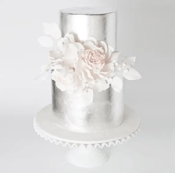 a silver wedding cake with white sugar blooms looks absolutely ethereal and extremely beautiful