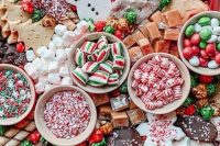 a Christmas wedding dessert board with chocolate, cookies, cakes, mint candies, marshmallows, M&Ms, and lots of other tastes