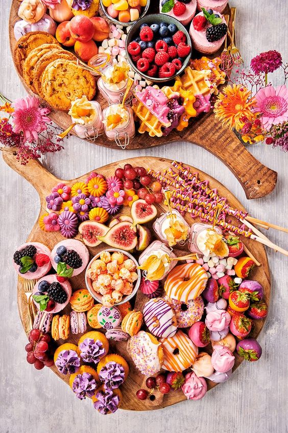 a grazing platter with delicious glazed donuts, cookies, macarons, cupcakes, meringues, pavlovas, candies and berries with glazing or not