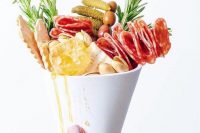 a jaw-dropping charcuterie cones with olives, honey, nuts, pickles, cookies, ham and herbs are amazing for a wedding