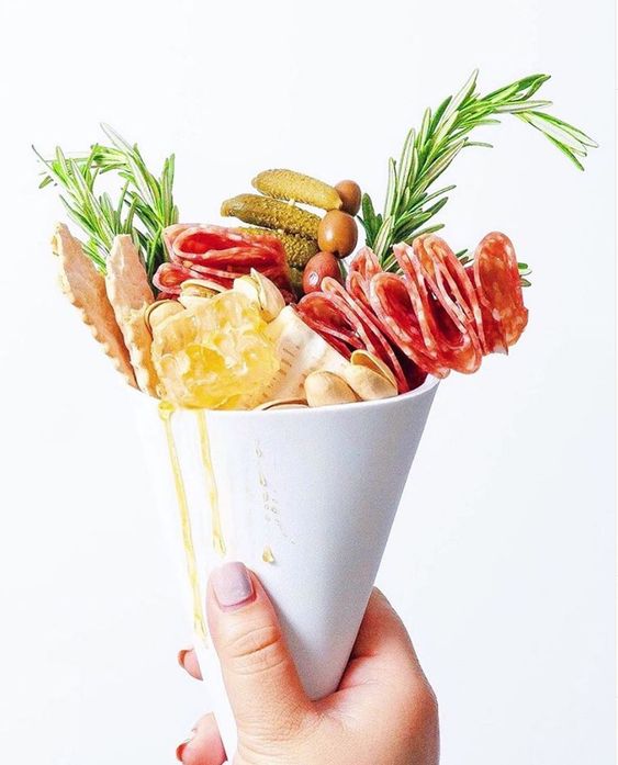 a jaw-dropping charcuterie cones with olives, honey, nuts, pickles, cookies, ham and herbs are amazing for a wedding