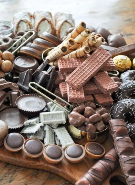 a jaw-dropping chocolate grazing table that includes waffles, various kinds of cookies, cupcakes, sweets and candies is amazing