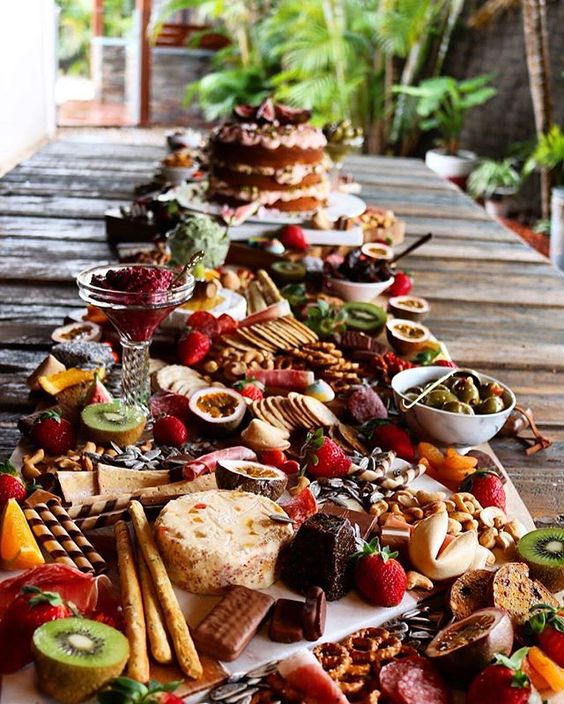 a jaw-dropping sweets grazing table with various kinds of cookies and waffles, fresh fruit and berries, cheese and dips plus ice cream