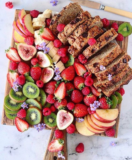a lovely grazing board with figs, strawberries, kiwis, raspberries, bananas and a delicious cake and apples is amaizng for a wedding