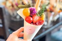 a mini grazing cone with tomatoes, a pickled cucumber, salami, herbs and a cookier is a lovely idea for a modern wedding
