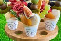 a mini stand with tiny charcuterie cones filled with cheese, pickles, fresh figs, salami, nuts and herbs is ideal for a wedding