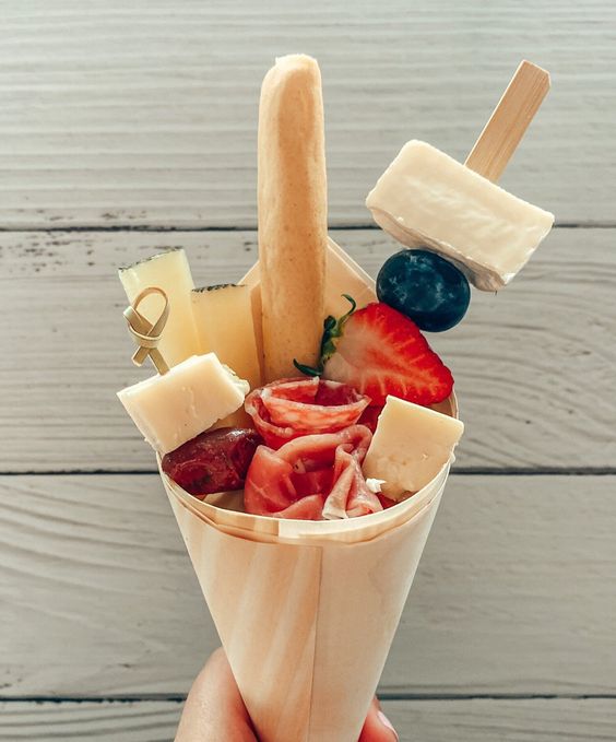 a pretty grazing cone with salami, dried and fresh fruit, various types of cheese, salami and ham is a cool idea for a modern foodie wedding