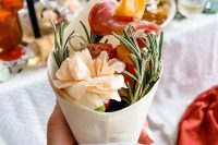 a romantic wedding charcuterie cone with herbs, salami, cheese, olives and a bloom is a lovely idea for a wedding