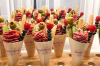 charcuterie cones with fresh berries, cookies, salami, vegetables, pickles and cheese are great for your wedding cocktail hour