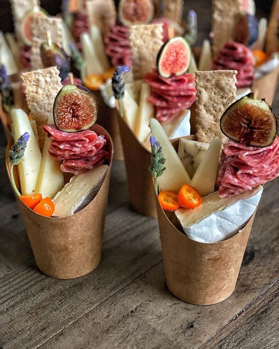 fantastic charcuterie cups of cardboard, with various types of cheese, tomatoes, salami, figs and cookies are amazing for a wedding