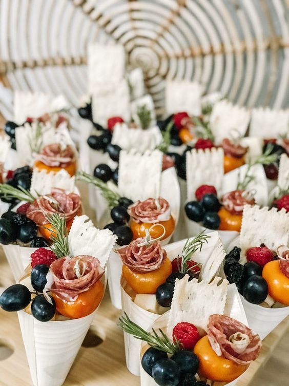individual charcuterie cones with fresh berries and vegetables, with cookies and herbs, ham and salami are amazing for a wedding