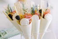 mini charcuterie cones with mini cheese pieces, salami, crackers, citrus and blackberries are amazing for a summer or a fall wedding