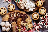 mini holiday dessert boards with waffles, cookies, candies, snowflake cookies, cakes, macarons and other delicious stuff for a winter wedding