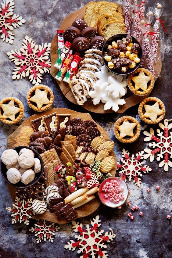 mini holiday dessert boards with waffles, cookies, candies, snowflake cookies, cakes, macarons and other delicious stuff for a winter wedding